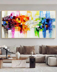 Colorful abstract painting on a wall above a sofa in a living room.